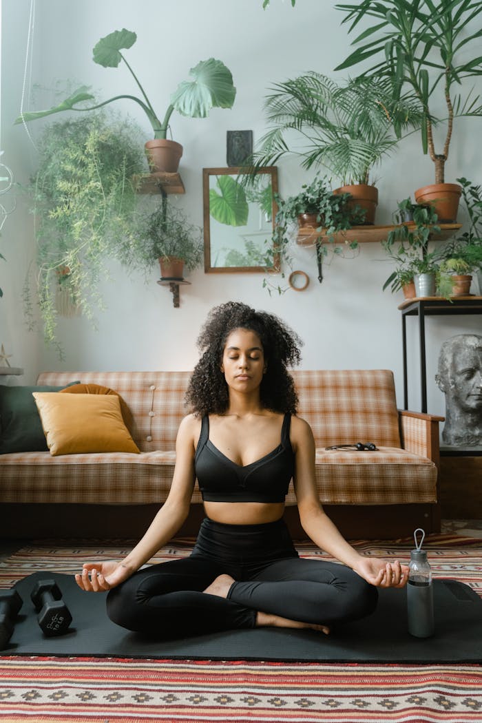 Crafting Captivating Headlines: Your awesome post title goes here Woman meditating on yoga mat indoors surrounded by plants, embodying calmness.